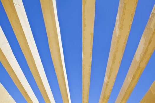 Horizontal detail of architecture to the roof of the public access to Shree Dwarakadheesh Krishna Temple at Dwarka Gujarat India. With no shelter creats an abstract patten of the concrete box work against the rich blue sky withour clouds