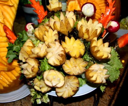 Potatoes on a platter with vegetables.