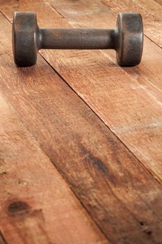 vintage iron rusty dumbbells on weathered red barn wood background - fitness concept