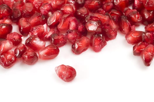 Selective focus on the foreground single pomegranate berry on white background