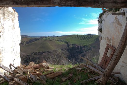 collapsed building with a view over rolling hills in Italy