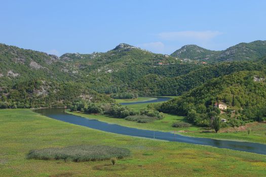 Rijeka Crnojevica river winding through lily pads and mountains in Montenegro