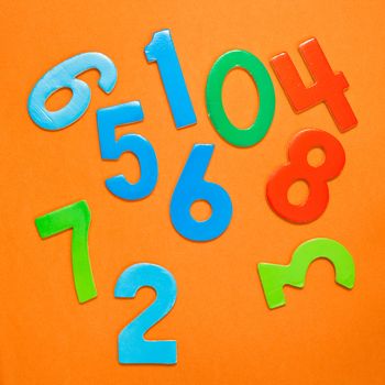 Square background image of toy numbers on orange background