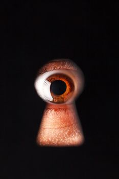 Eye looking through a keyhole