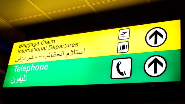Baggage claim and telephone sign in an international airport in Middle East with Arabic information