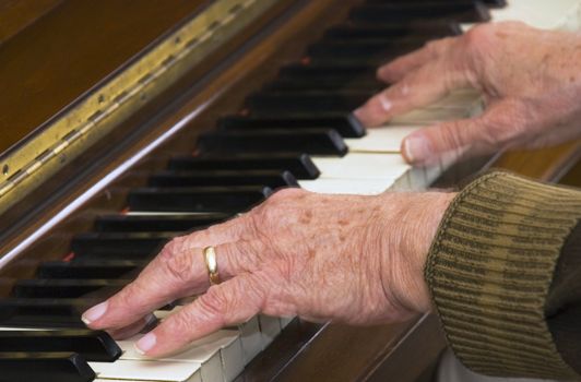 Selective focus on hands in the foreground of the pianst - rear flash to show slight movement.