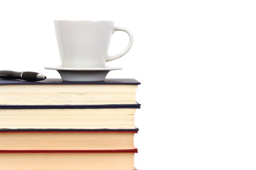Cup and pen on stack of books