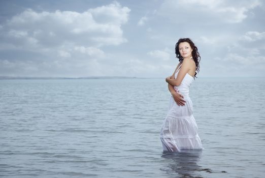 Woman with wet skirt standing in the water