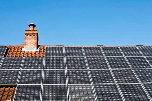 Modern solar panels on a tiled roof in the sunlight