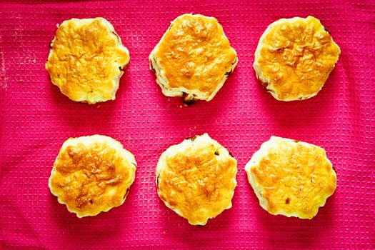 Six freshly baked scones on a pink cloth