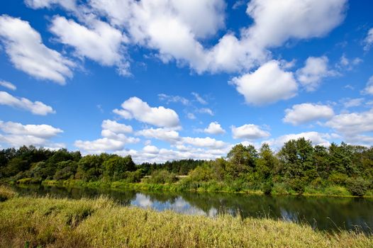 Summer landscape with river and cloudy sky