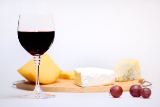 Glass of red wine and cheese plate