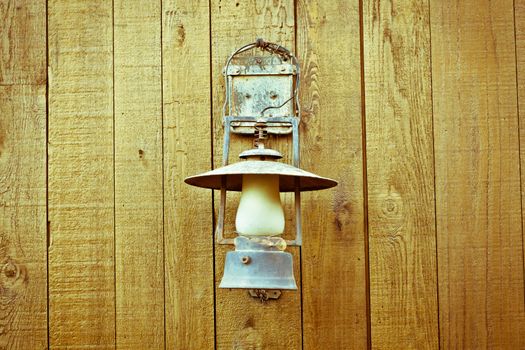 A nice vintage paraffin lamp mounted on a wooden wall