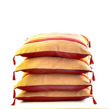 A stack of colorful moroccan cushions on a white background