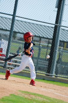 Youth baseball boy swinging the bat.