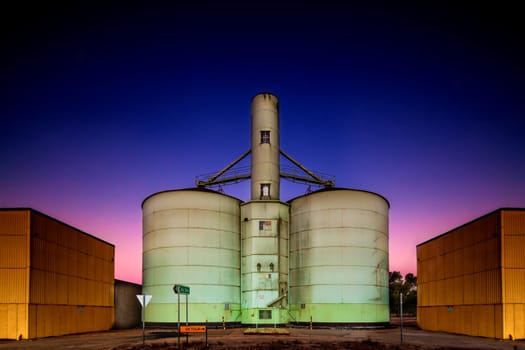 Old grain storage rustic silo during a stunning pink purple blue dusk sunset in country Victoria of Australia