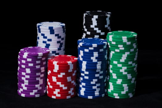 Stacks of Multicolored Poker Chips, closeup on black background