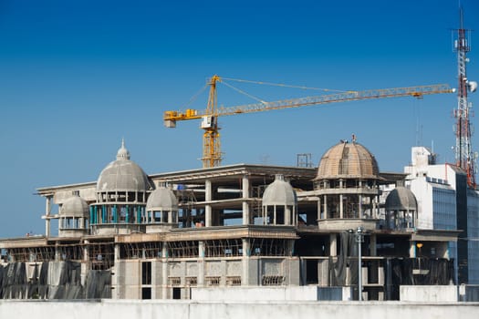 Construction of large buildings. Cranes are used to lift.
