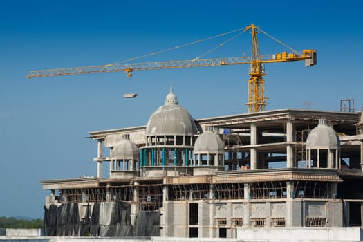 Construction of large buildings. Cranes are used to lift.