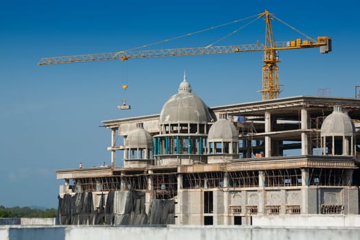 Construction of large buildings. Cranes are used to lift.