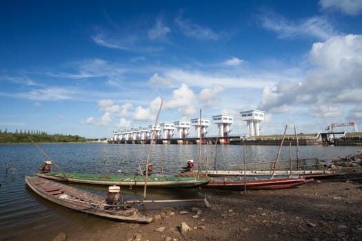 Traditional fishing boats parked along the waterfront near the floodgates.