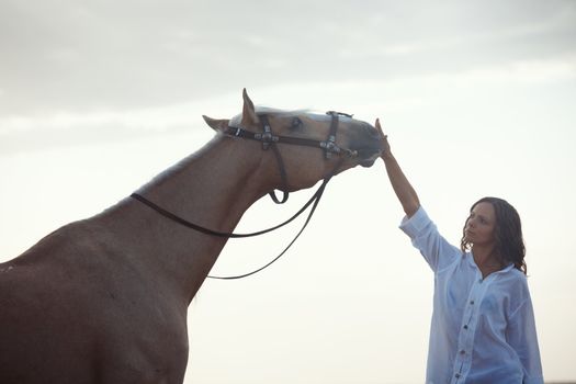 Woman training horse outdoors during sunrise