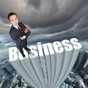 Businessman in suit standing on the word Business