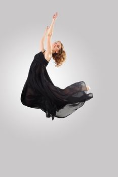 Young female dancer jumping against white background