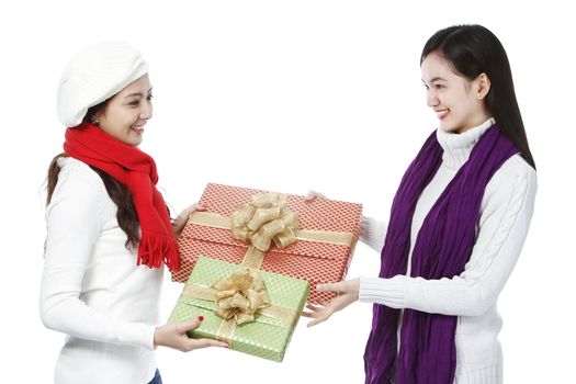 Two young women exchanging gifts (on white background)