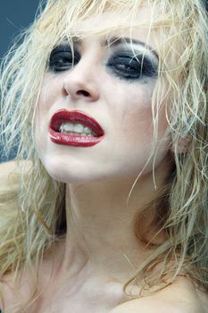 Crazy blond lady with bizarre makeup. Studio photo