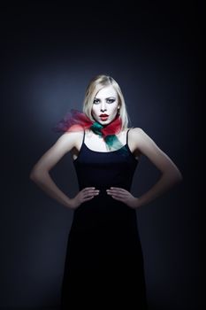 Top model in elegant dress with perfect makeup on a dark background