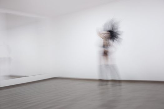 Motion blur of the woman performing dance in ball room