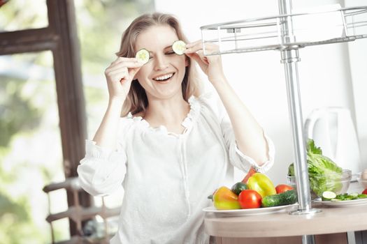 Laughing blond lady at the kitchen preparing breakfast