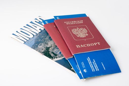 Two russian passports with airplane tickets and Monaco tourist map
