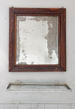 Mirror in a dilapidated white bathroom