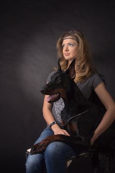 Woman with dobermann dog on black background