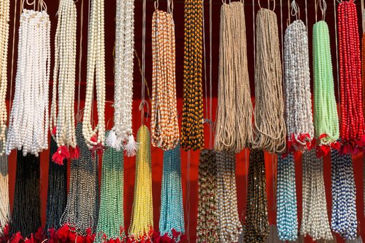 Strands of small colorful beads at the outdoor craft open market in India
