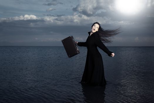 Screaming traveler with bag moving into the sea