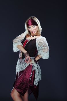 Lady in traditional costume performing national dance on a dark background