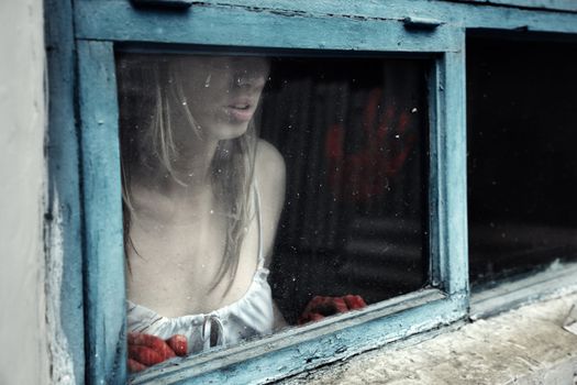 Woman with bloody hand behind the window