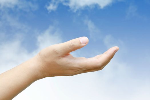 Male hand held up with blue sky and cloud.