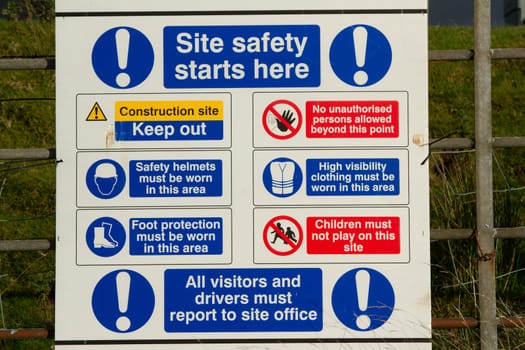 A white board with symbols and warnings explaining site safety rules and precautions.