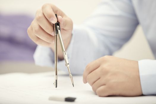 Hands of engineer working with compasses