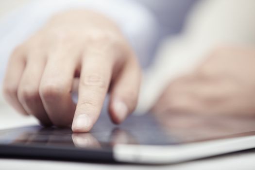 Hands of businessman using tablet PC at office