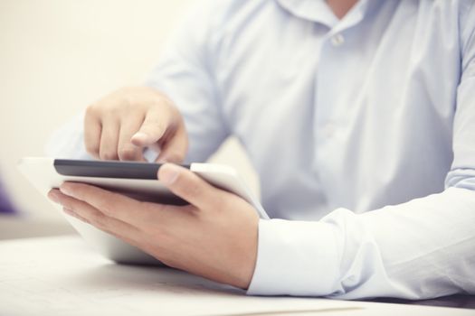 Hands of businessman using tablet PC at office