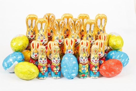 group of many color easter chocolate rabbits bunny and eggs on white background