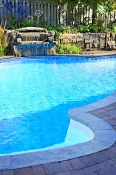 Outdoor inground residential private swimming pool with waterfall