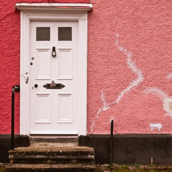 White front door in a pink wall