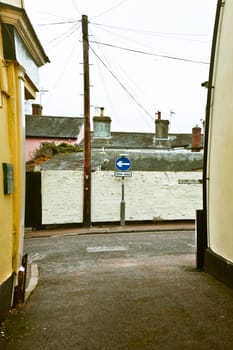 One way sign on a street seen through an alley way