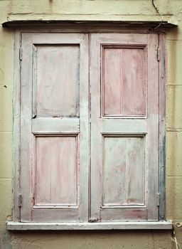 Closed wooden shutters in a brick wall